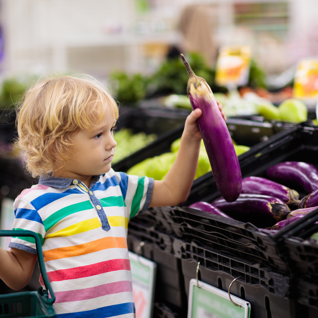 Kind kauft Gemüse im Supermarkt